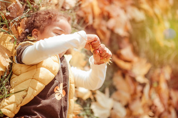 happy little child, baby girl laughing and playing in the autumn on the nature walk outdoors.