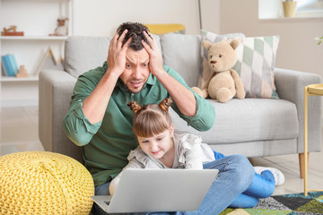 Obraz premium Little daughter keeping father from his work at home