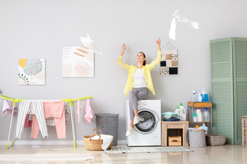 Woman having fun while doing laundry at home