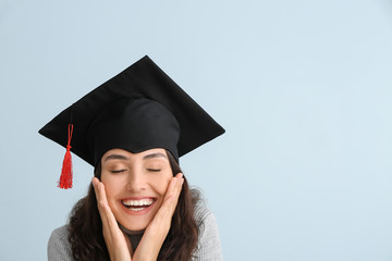 Female graduating student on light background