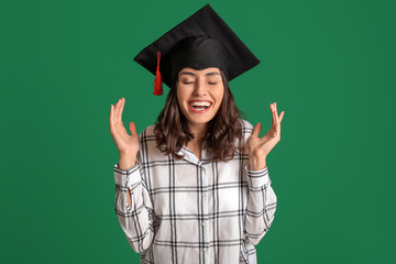 Happy female graduating student on color background