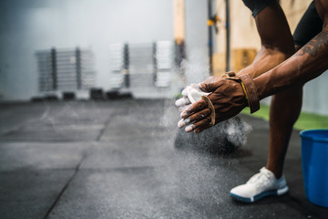 Fitness man rubbing hands with chalk magnesium powder. © Mego-studio
