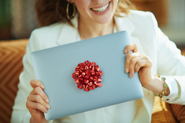 woman and gift laptop with red bow in house in sunny day