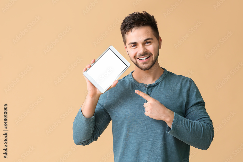 Poster young man with tablet computer on color background