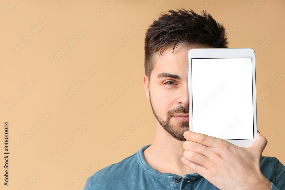 Poster young man with tablet computer on color background