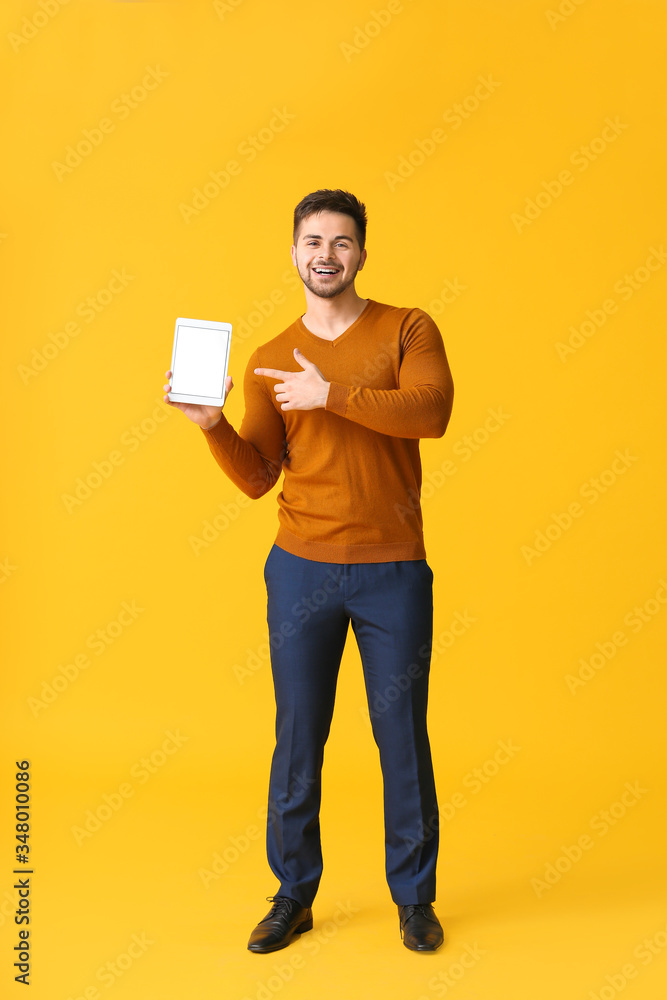 Poster young man with tablet computer on color background