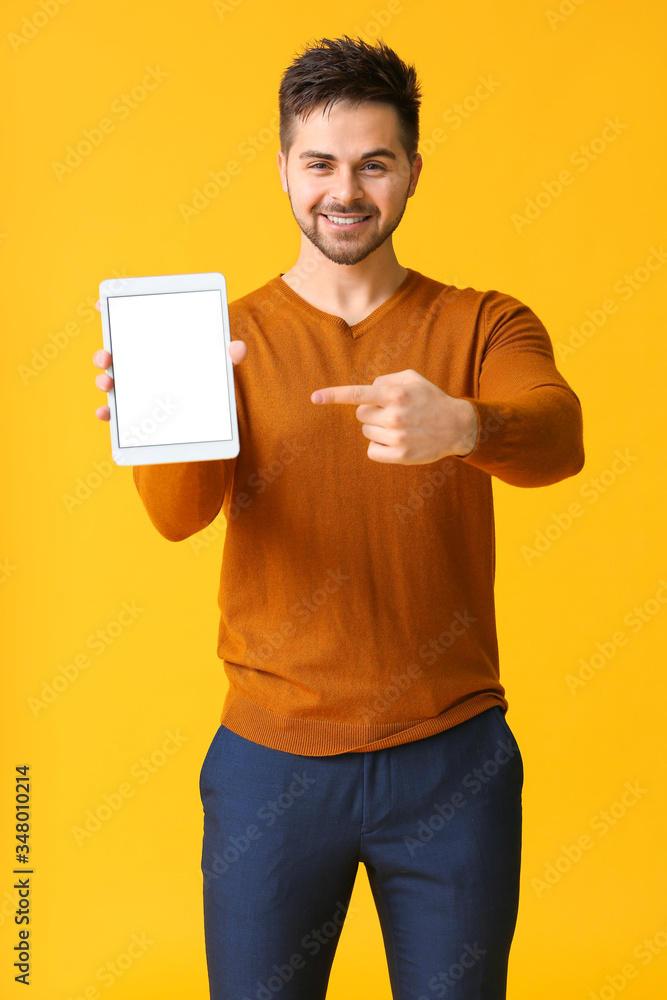 Poster young man with tablet computer on color background