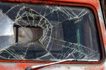 Close up of broken windshield of an old red pickup truck