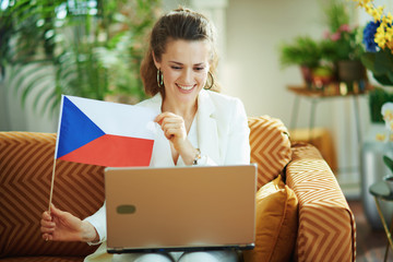 woman with laptop having video call and showing Czech flag