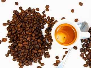 espresso on a bed of coffee.Roasted coffee beans background.Cup of coffee on beans