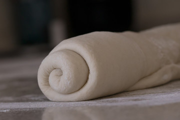 Fototapeta na wymiar Rolled bread dough on a floured kitchen counter waiting to be shaped into a loaf of bread.