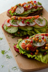 open sandwich with beetroot hummus with vegetables and tomato sauce. Healthy vegan food concept.