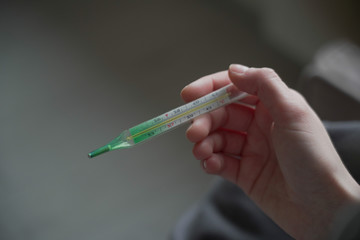 Female hands holding a thermometer