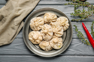 Plate with tasty dumplings on wooden background