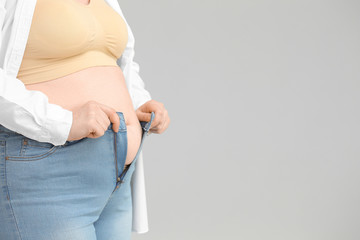 Overweight woman on grey background, closeup