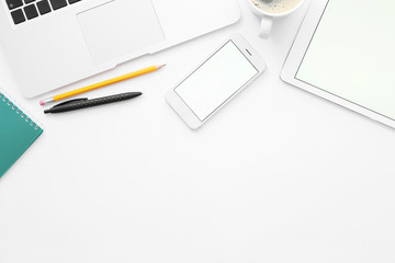 Tablet computer, mobile phone, laptop and stationery on white background