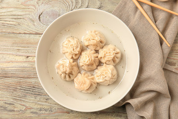 Plate with tasty dumplings on table