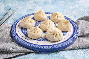 Plate with tasty dumplings on color background