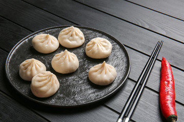 Plate with tasty dumplings on table