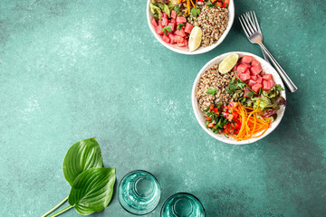 Vercion of Hawaiian tuna poke bowl with quinoa. tropical turquoise background