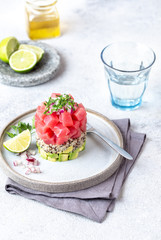 Tuna tartare tartar with avocado and quinoa. gourmet presentation with culinary ring on wite plate