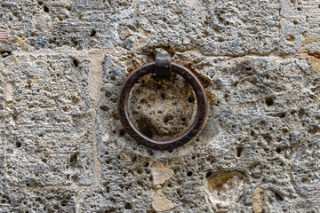 An old horse hitch made in iron used lined Anouilh the iron eroded the stone behind it. 