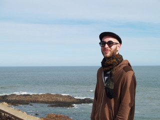 man with beard, sunglasses, beret and scarf on the sea