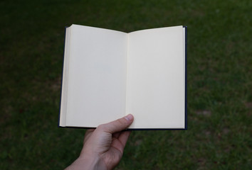 White open notebook held by hand. POV.