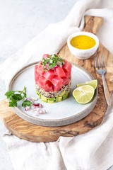 Tuna tartare tartar with avocado and quinoa. gourmet presentation with culinary ring on wite plate