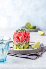 Tuna tartare tartar with avocado and quinoa. gourmet presentation with culinary ring on wite plate