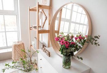 Interior of room with stylish mirror and spring flowers