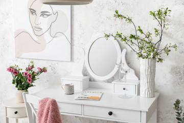 Interior of room with stylish mirror and spring flowers