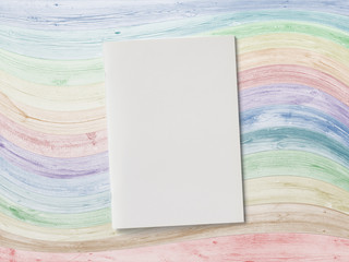 Blank Magazine or Brochure on colored wooden desk. Front cover top view. Template concept for your showcase.