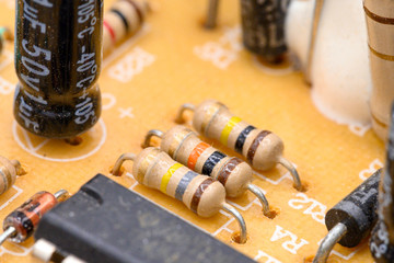 Old vintage printed circuit board with electronic components. Closeup with shallow DOF .