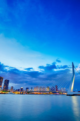 Dutch Travel Destination. View of Renowned Erasmusbrug (Swan Bridge) in  Rotterdam in front of Port and Harbour. Picture Made At Dusk.