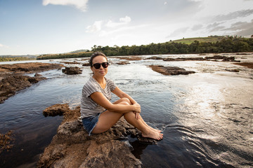 Mulher relaxa cercada de água no Rio Ivaí, localidade de Salto Fogueira, em Borrazópolis, estado do Paraná