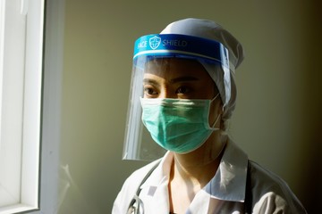 Fototapeta na wymiar Close up face doctor of female asian wearing protection Suit , Green mask,face shield and blue gloves for Fighting Covid-19 (Corona virus) with white background