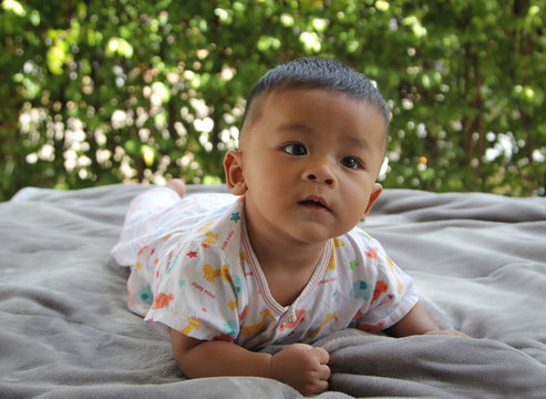 Southeast Asian newborn baby. Crawling in the house. Kid is cute. Child is taking photo indoor. Infant is 5 months. - People, Health care concept.