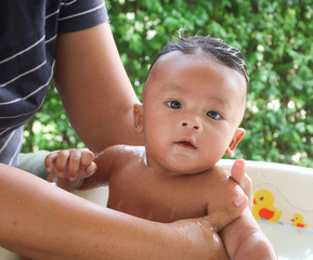 The baby showered her hair with the mother bathing baby. The baby looked at the mother with the beloved eyes.