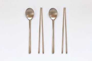 Korean high quality brass tableware. Spoons and chopsticks isolated on white background. Top view.
