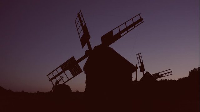 Fixed idle windmills at night. Silhouettes of mills.