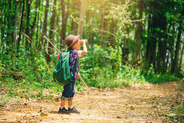 Children go hiking at backyard with backpacks at forest path. Explorer and adventure with toy...