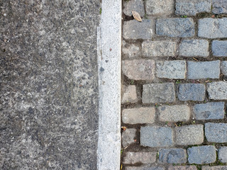 Calçada de cimento e rua de paralelepípedo 