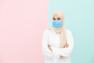 Muslim woman wearing medical mask for prevent infection virus on pastel color background. Coronavirus(covid-19) concept