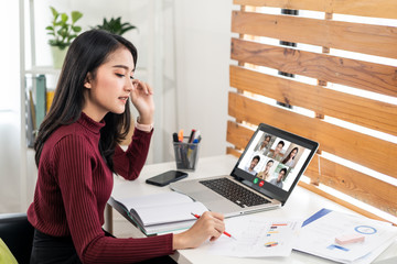 Asian business woman talking to colleague team about plan in video conference. Group of multiethnic...