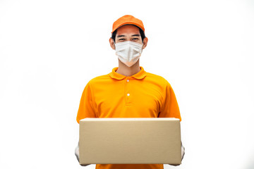 Fototapeta na wymiar Asian deliver man wearing face mask in orange uniform holding box of food, groceries, things standing in white isolated background. Postman and express grocery delivery service during covid19 pandemic