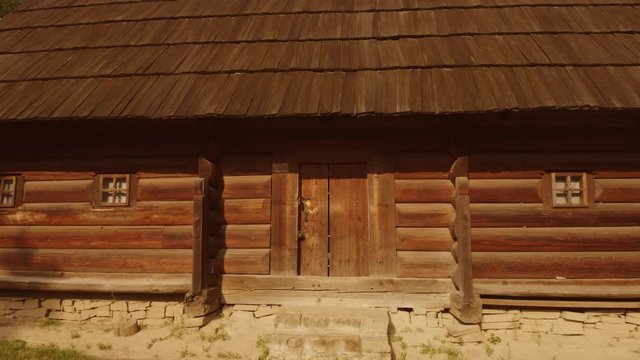 Close up door of an ancient medieval wooden log house. Moving away from a hut. Traditional shack house in a forest.