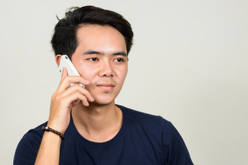 Portrait of young Asian man talking on the phone
