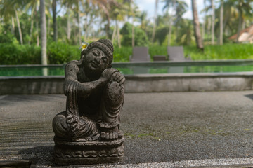 Fototapeta na wymiar Grey Stone Statue with Flower in Ear