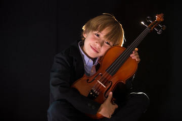 boy hugging his violin, in an attitude of love for music
Boy shows his violin to the camera